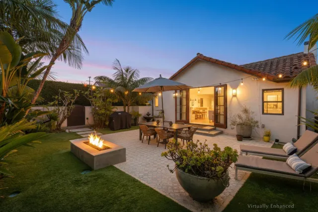 a view of a patio with couches table and chairs and potted plants