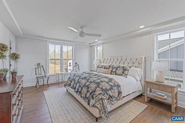 a bedroom with a large bed and windows
