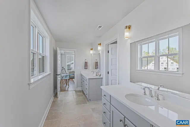 a spacious bathroom with a double vanity sink a mirror a shower and a bathtub