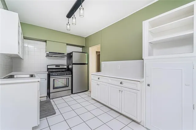 a kitchen with a refrigerator and a stove top oven