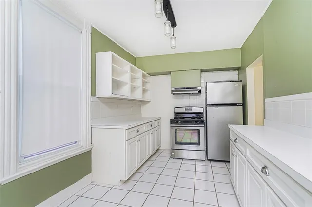 a kitchen with stainless steel appliances a refrigerator sink and cabinets