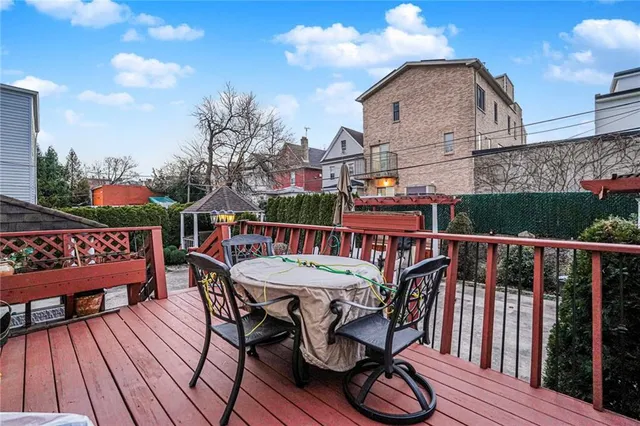 a view of a roof deck with table and chairs with wooden floor and fence