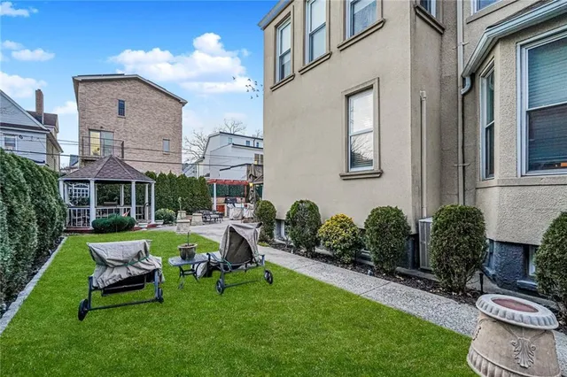 a front view of a house with garden and chairs