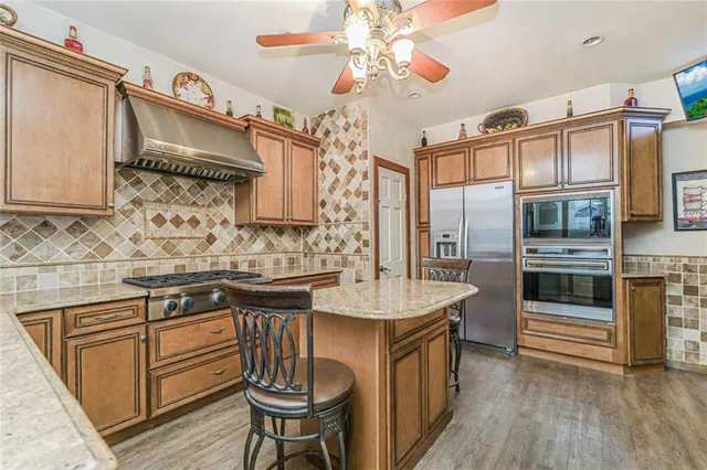 a kitchen with stainless steel appliances granite countertop a sink and cabinets