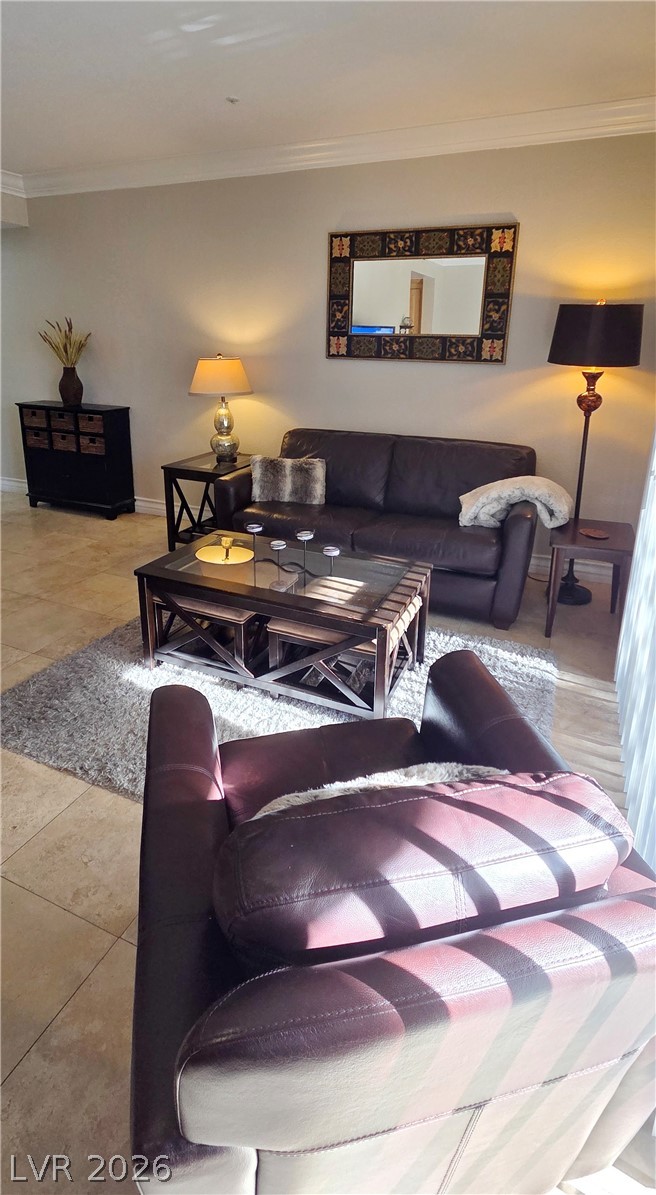 210 East Flamingo Road, Unit 208 Las Vegas, NV 89169 - Photo 9 of 42 Sun-filled living area featuring elegant tile flooring and crown molding.