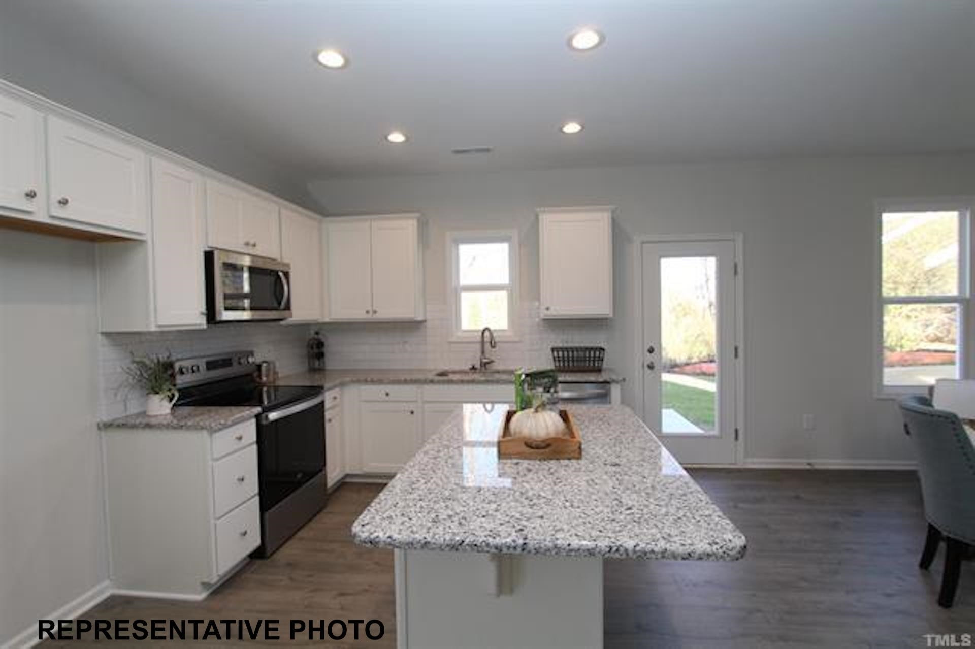 113 Springtooth Drive Zebulon, NC 27597 - Photo 3 of 13 a kitchen with a stove a sink a microwave a counter top space and cabinets