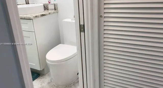 a white toilet sitting next to a shower