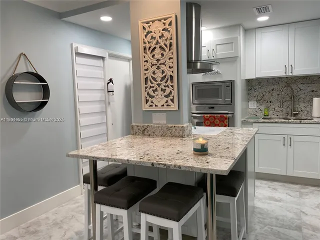 a kitchen with granite countertop a sink and a stove