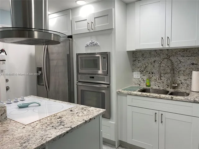 a kitchen with a sink refrigerator and microwave