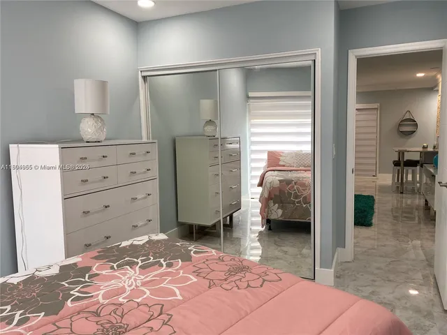 a bedroom with a bed and a view of living room