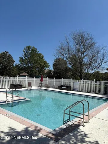 a view of a swimming pool with a patio and a yard