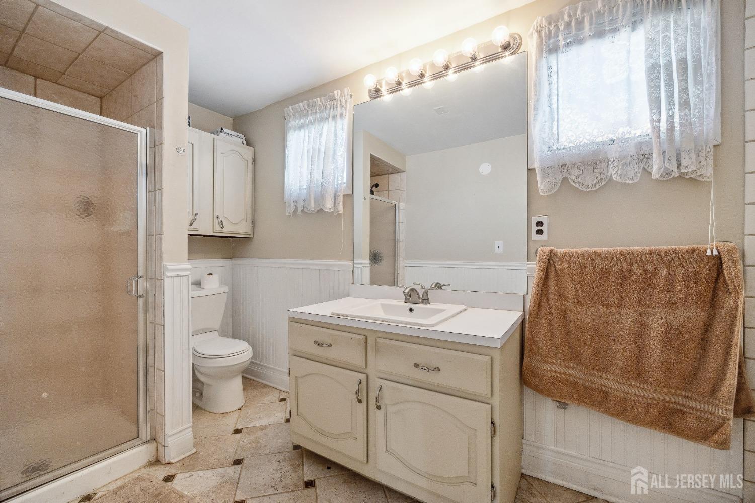 123 Madison Avenue Perth Amboy, NJ 08861 - Photo 22 of 30 a bathroom with a sink a toilet and a mirror