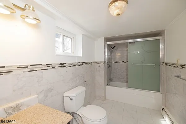 a bathroom with a granite countertop toilet sink and mirror