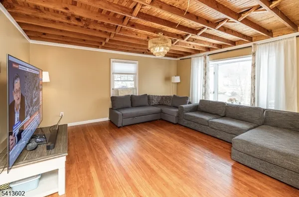 a living room with furniture a flat screen tv and a floor to ceiling window