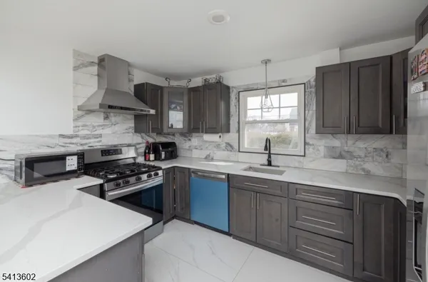a kitchen with stainless steel appliances a sink stove and cabinets