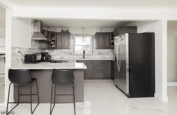 a kitchen with stainless steel appliances granite countertop a sink a stove a refrigerator and island