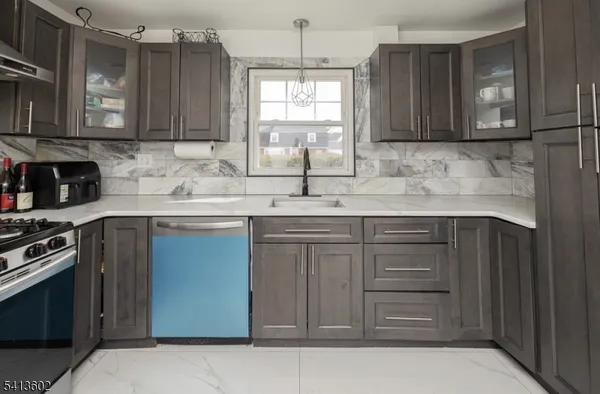 a kitchen with stainless steel appliances granite countertop a sink stove and microwave
