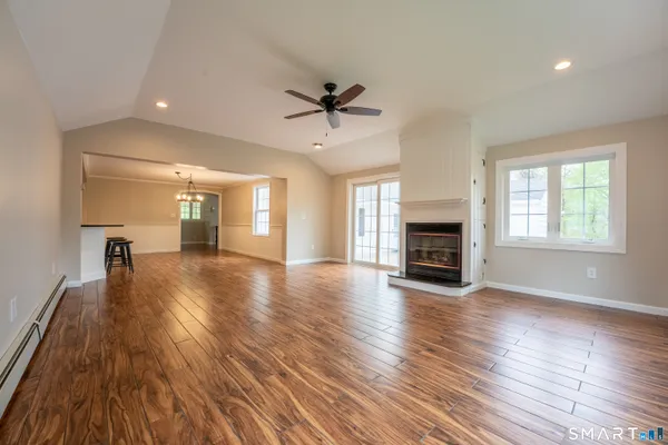 an empty room with fireplace windows and wooden floor