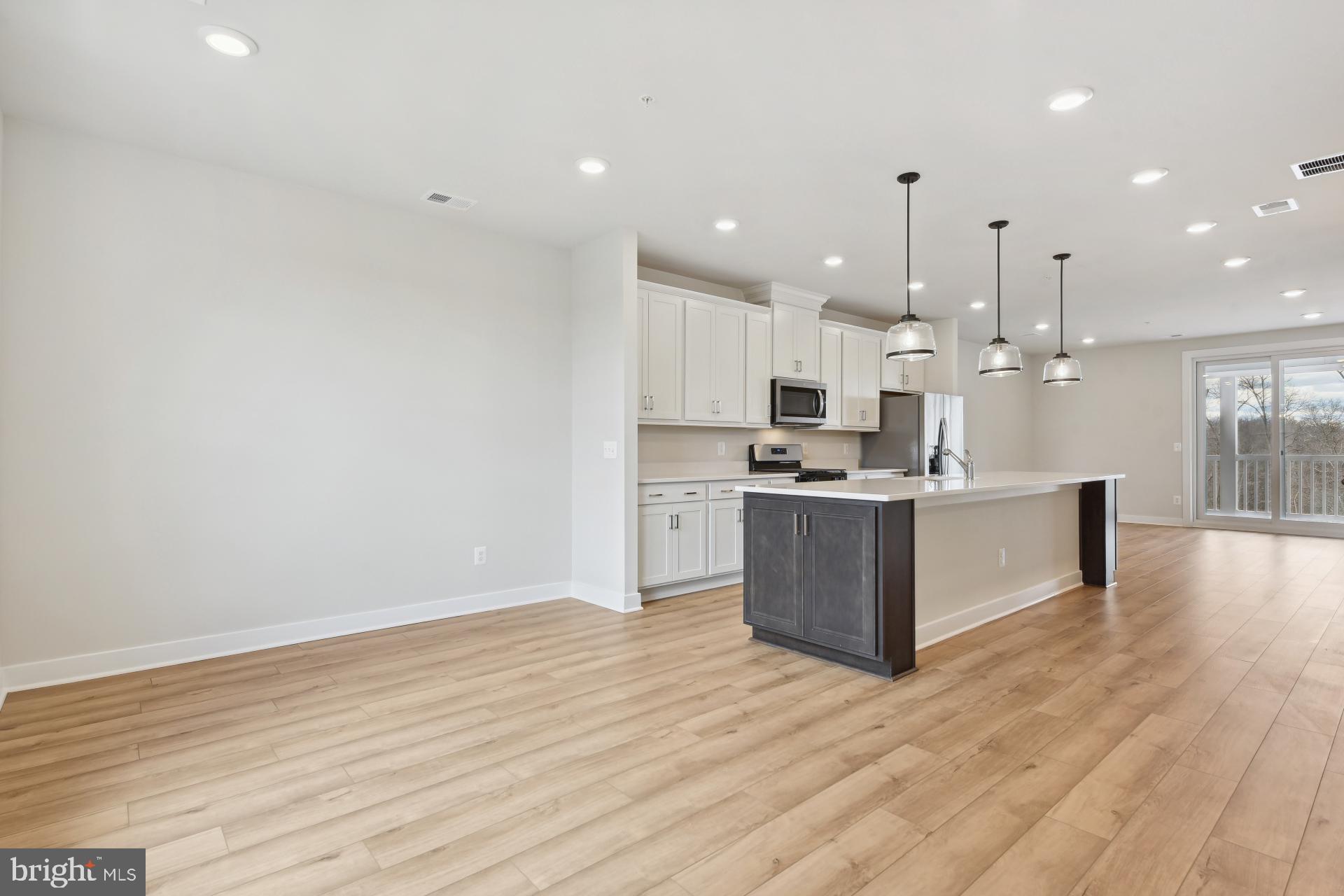 20783 Rumbullion Drive Sterling, VA 20166 - Photo 19 of 20 a large kitchen with kitchen island a sink wooden floor and stainless steel appliances