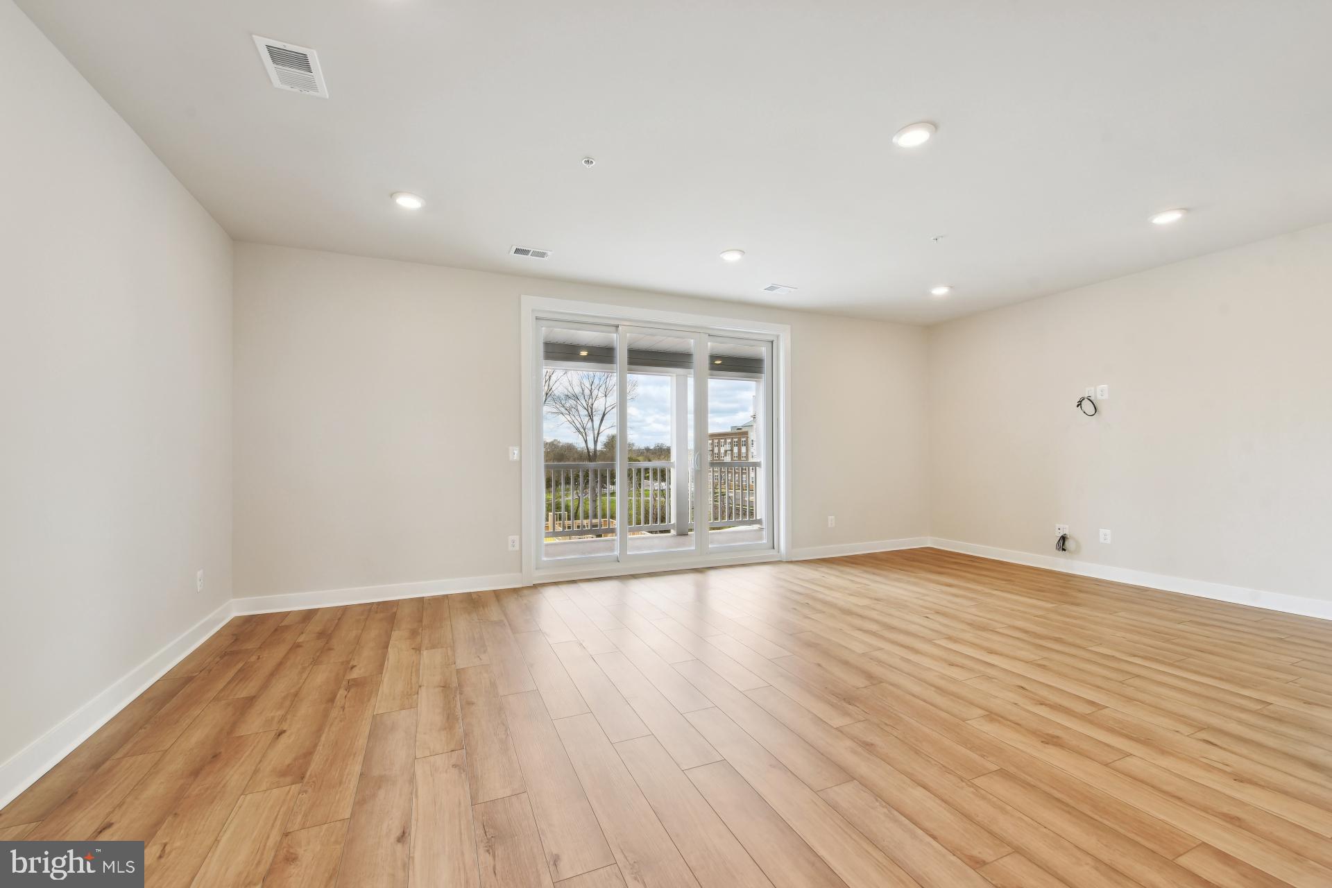 20783 Rumbullion Drive Sterling, VA 20166 - Photo 4 of 20 a view of an empty room with wooden floor and a window