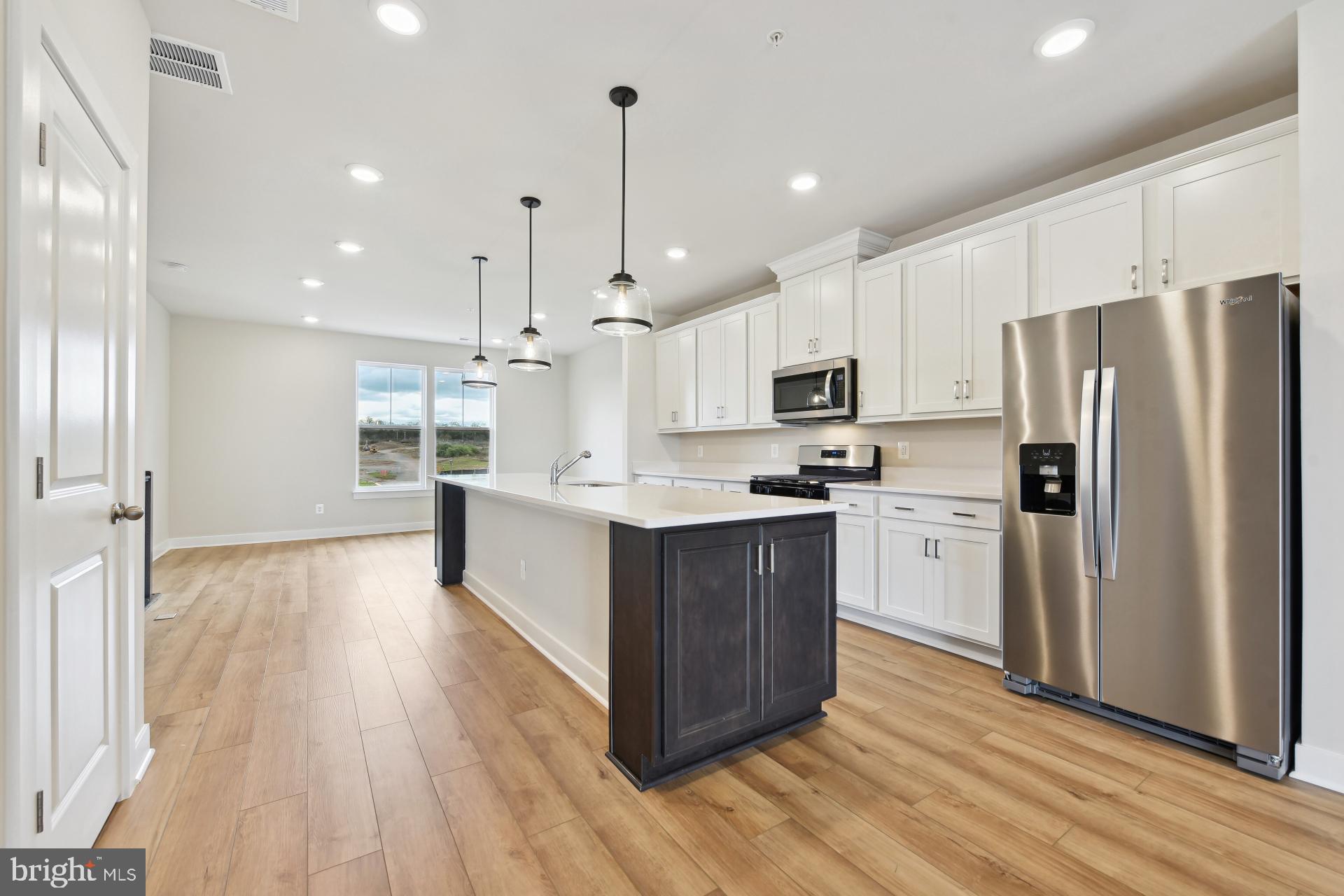 20783 Rumbullion Drive Sterling, VA 20166 - Photo 6 of 20 a large kitchen with stainless steel appliances and wooden floors