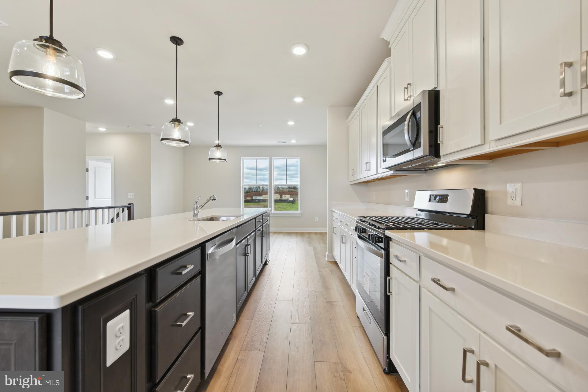 20783 Rumbullion Drive Sterling, VA 20166 - Photo 7 of 20 a kitchen with stainless steel appliances granite countertop a sink a stove and a wooden floors