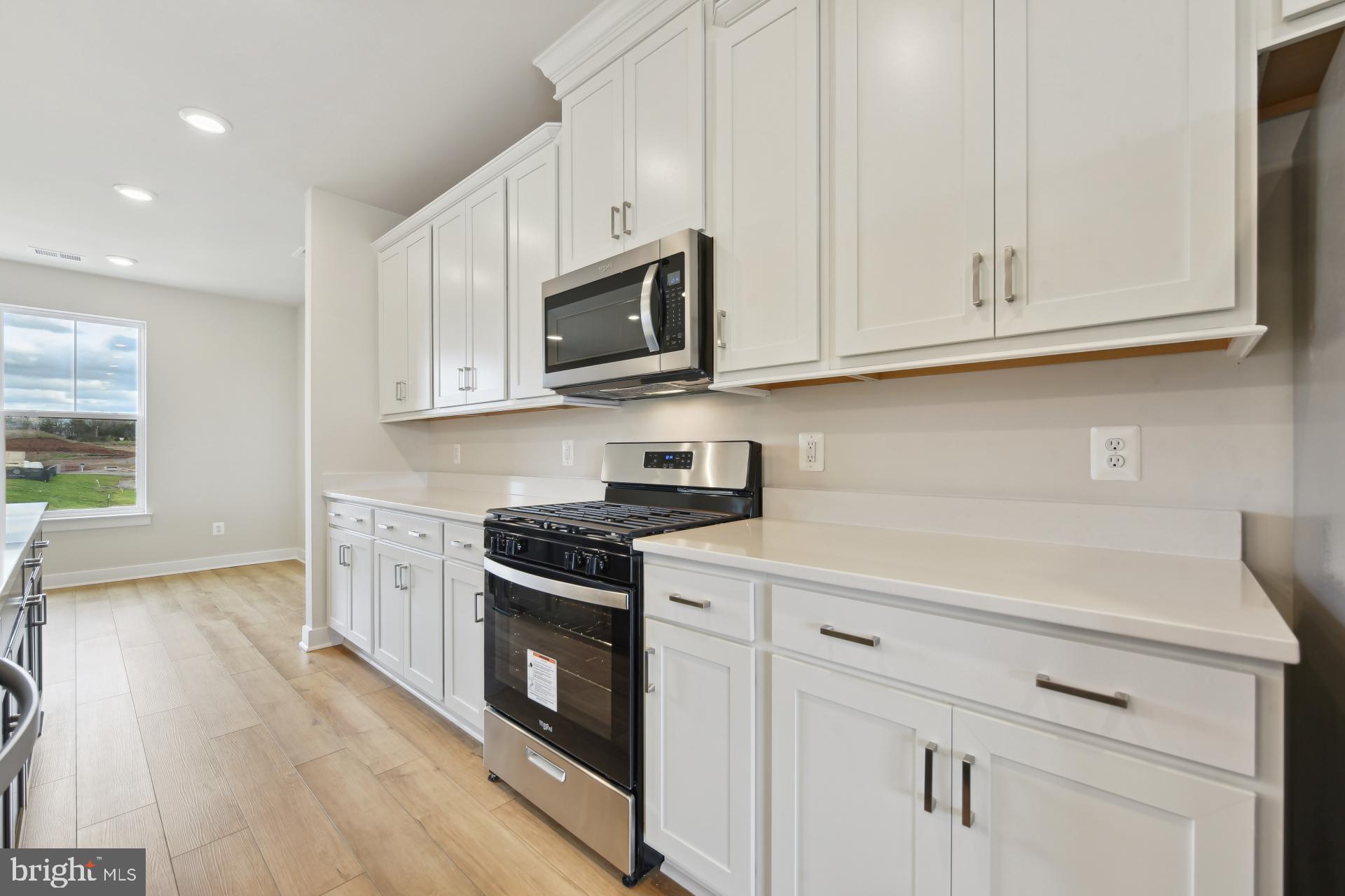 20783 Rumbullion Drive Sterling, VA 20166 - Photo 8 of 20 a kitchen with white cabinets and stainless steel appliances