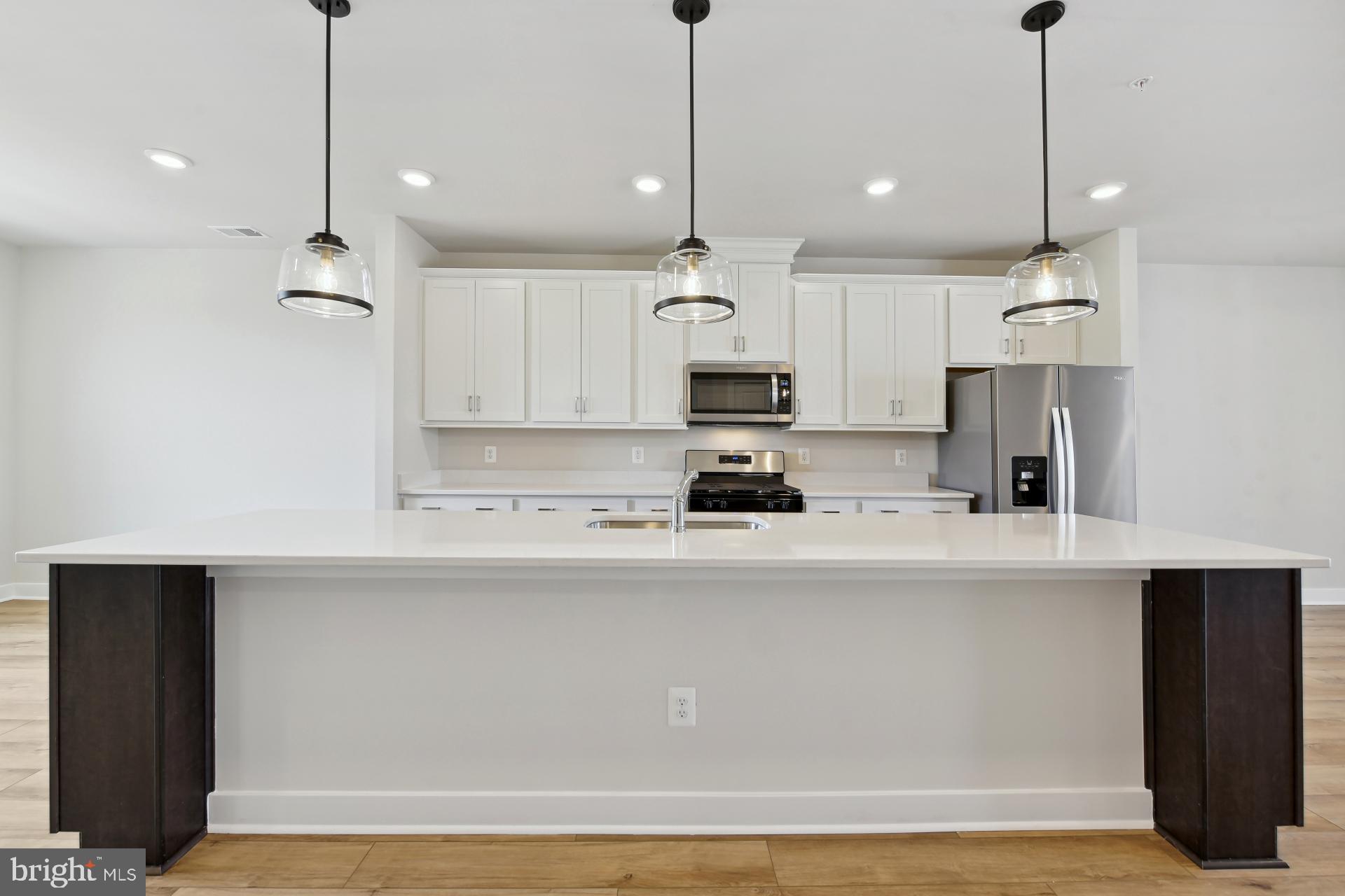 20783 Rumbullion Drive Sterling, VA 20166 - Photo 9 of 20 a kitchen with stainless steel appliances a refrigerator a sink and a stove