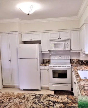 a kitchen with a stove top oven and cabinets