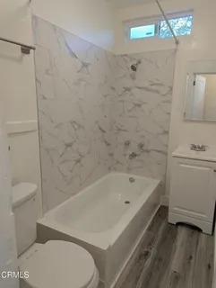 a view of a room with wooden floor and fan