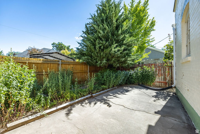 299 West Center Street, Unit 2 Logan, UT 84321 - Photo 31 of 46 Concrete patio area featuring a perimeter fence and mature landscaping