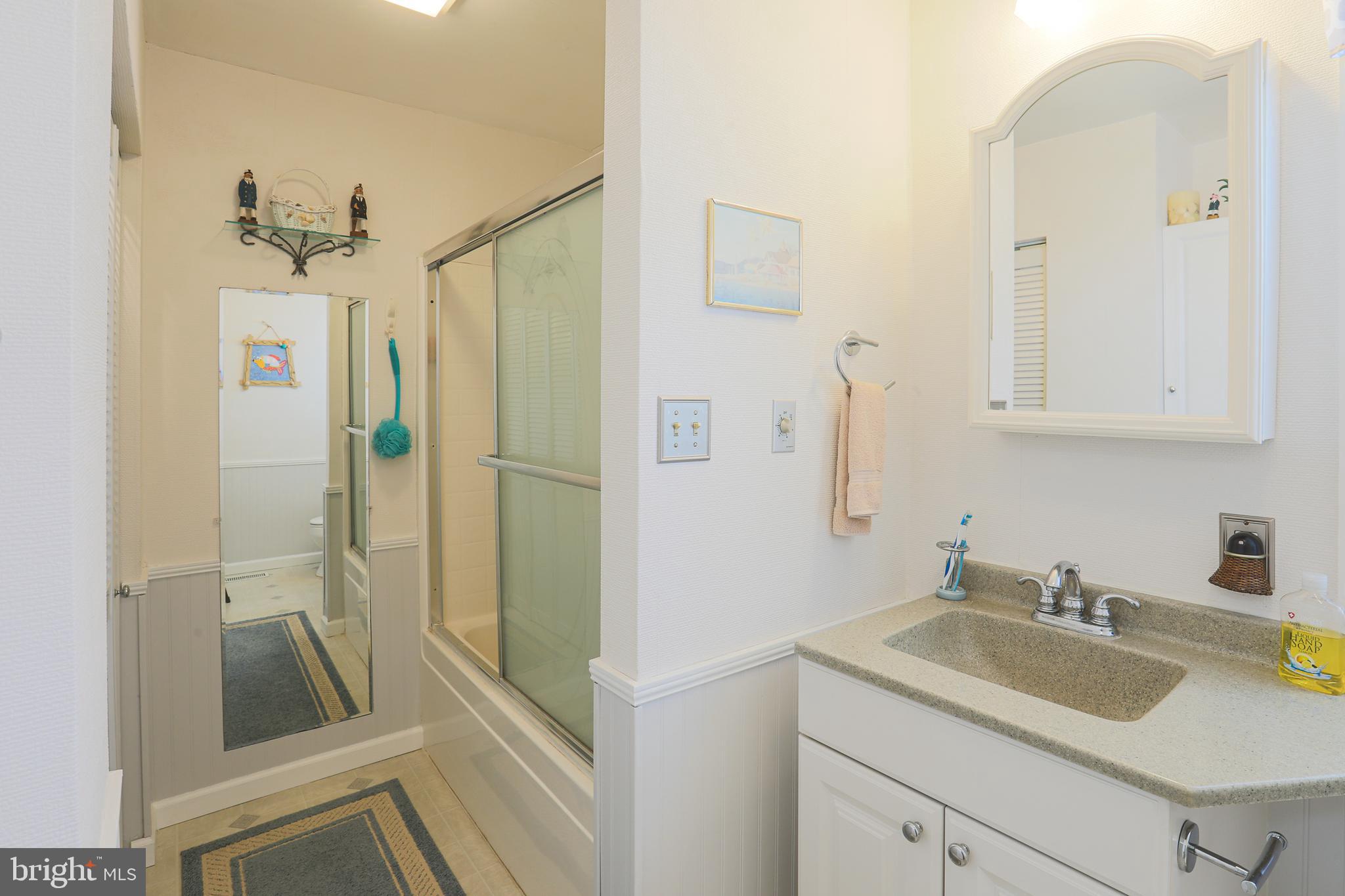 8247 Longpoint Road Baltimore, MD 21222 - Photo 22 of 54 a bathroom with a granite countertop sink a mirror a vanity and shower