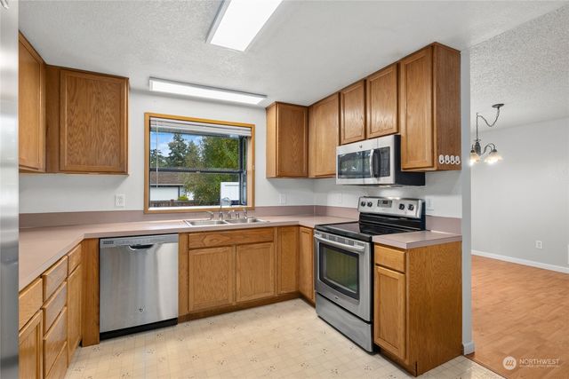 a kitchen with stainless steel appliances granite countertop wooden cabinets a sink and a stove
