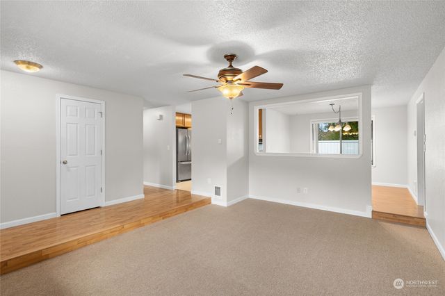 a big room with chandelier fan and windows