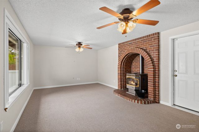 an empty room with windows and ceiling fan