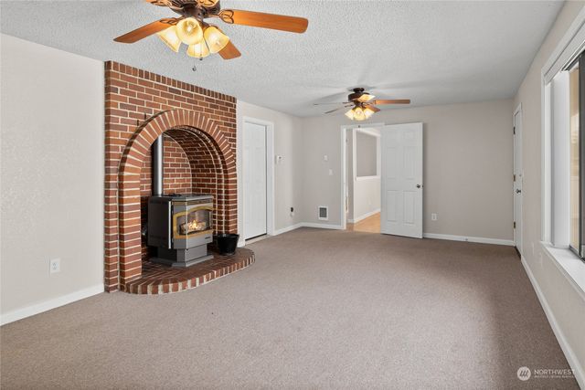 an empty room with ceiling fan and window