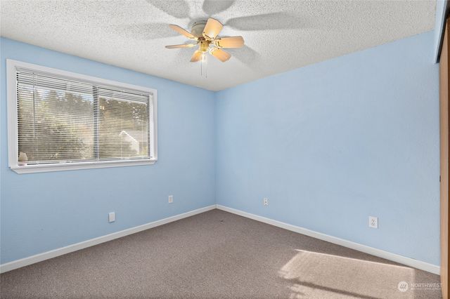 an empty room with a window and a fan