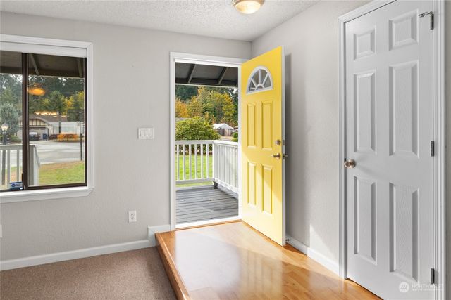 a view of a hallway with wooden floor and windows