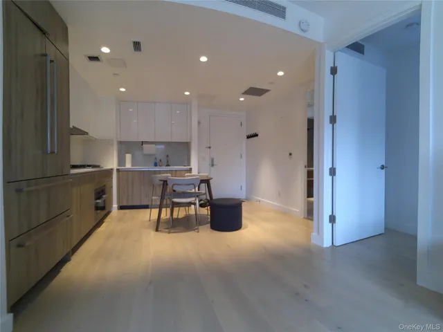 a kitchen with stainless steel appliances kitchen island granite countertop a refrigerator and a sink