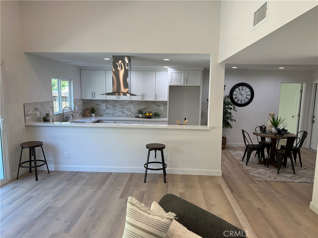 1711 Heather Avenue Tustin, CA 92780 - Photo 9 of 13 a living room with stainless steel appliances furniture a clock and a view of kitchen