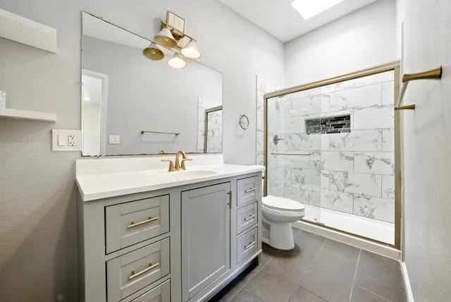 a bathroom with a double vanity sink toilet and shower