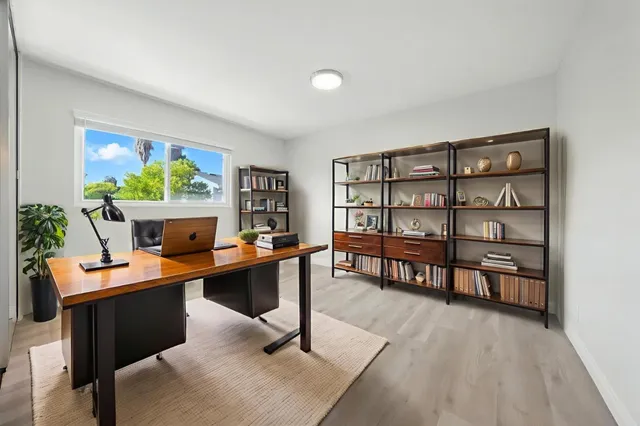 a view of a workspace with furniture and a window