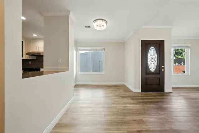 a view of empty room with wooden floor and fan
