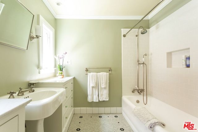 a bathroom with a tub sink toilet and mirror