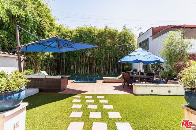 a view of pool with table and chairs under an umbrella