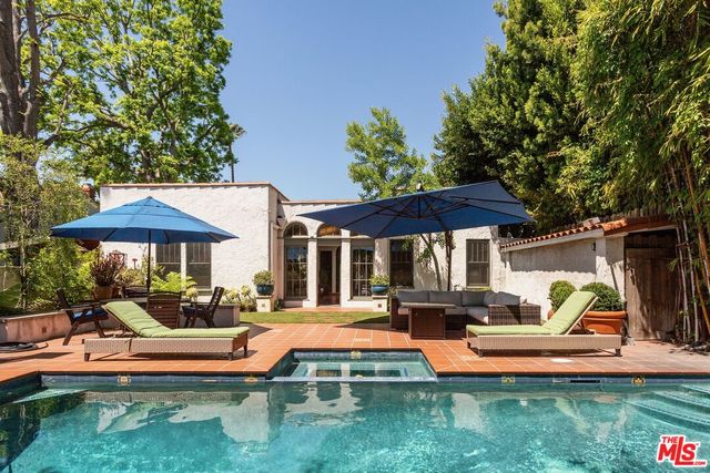 a front view of a house with swimming pool garden and patio