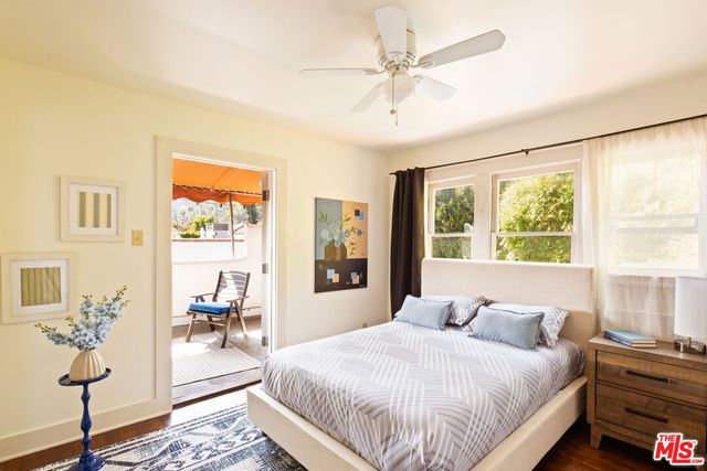 a bedroom with a large bed a chandelier and windows