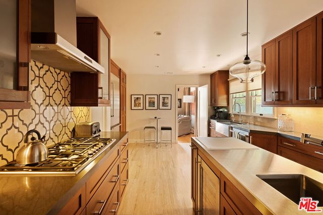 a kitchen with stainless steel appliances granite countertop a sink stove and cabinets