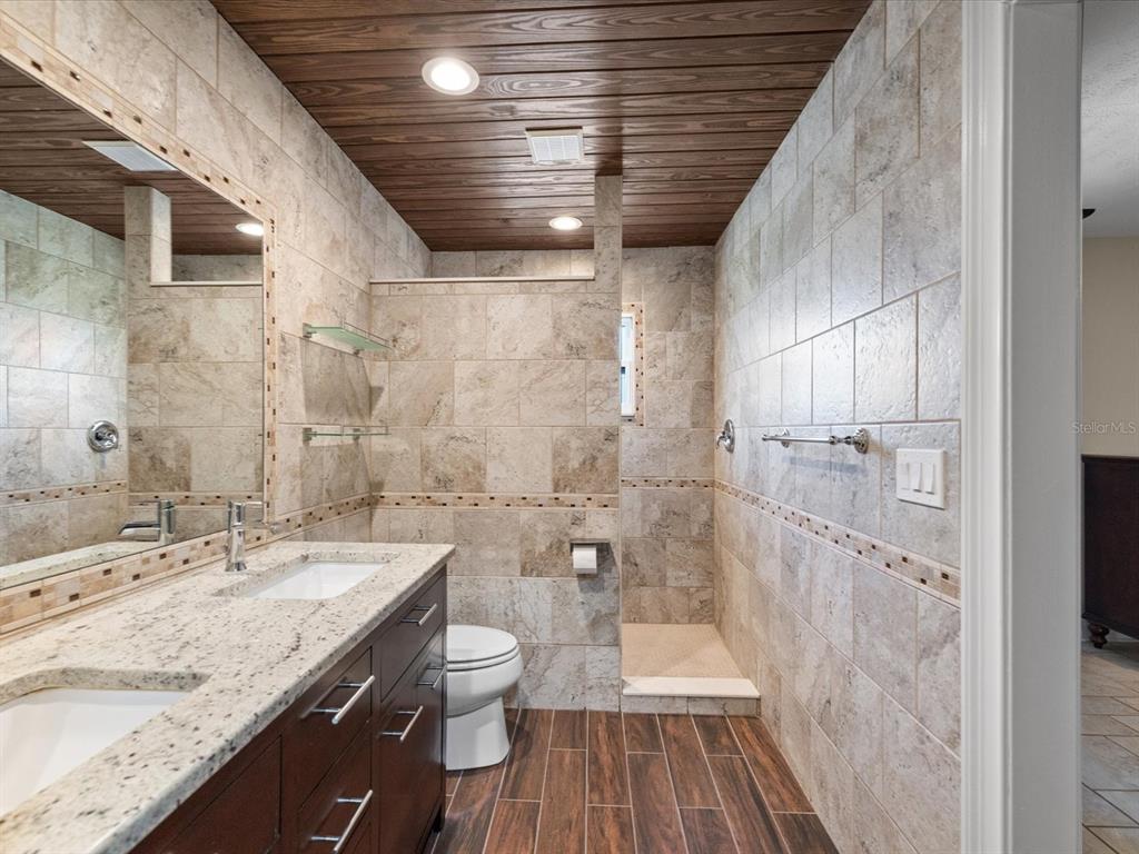 5904 Springrun Court Holiday, FL 34690 - Photo 26 of 53 a bathroom with a granite countertop sink a toilet and shower