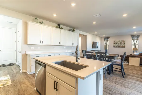 a kitchen that has a sink a table and chairs in it